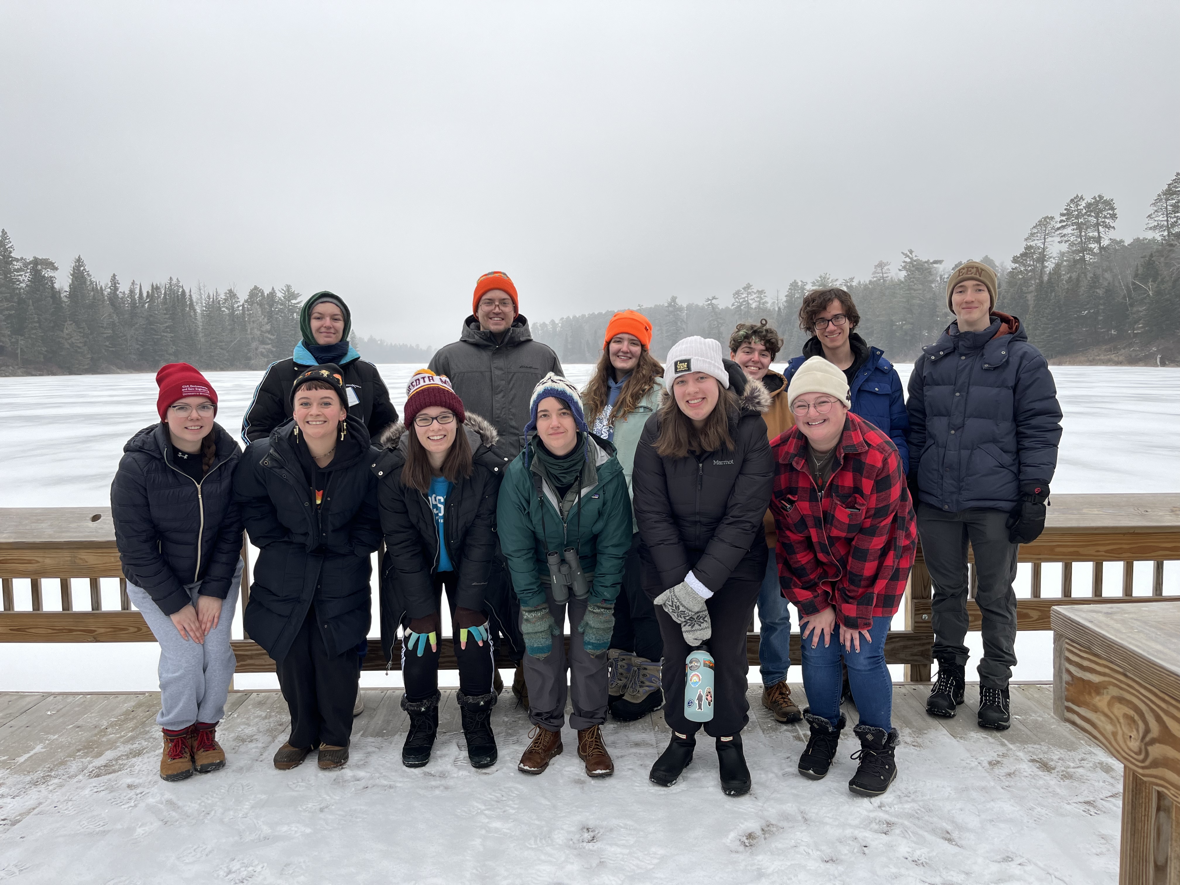 IBSL Booster Club members posing for a group picture at the end of a pier on Lake Itasca in the winter