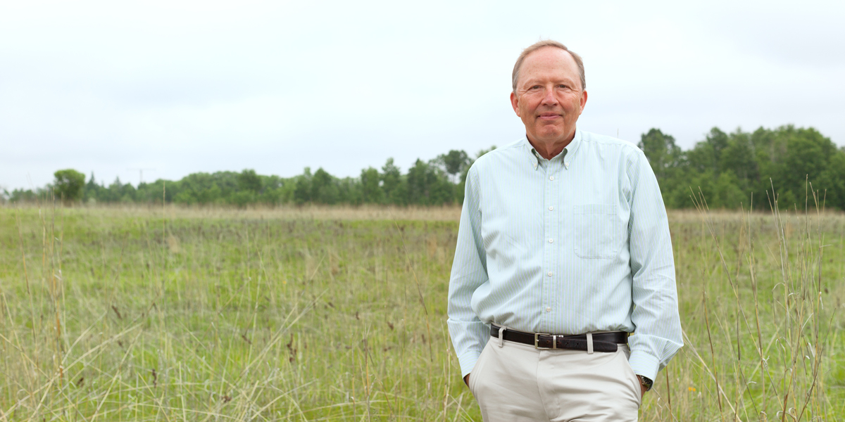 Dave Tilman standing in a field at Cedar Creek
